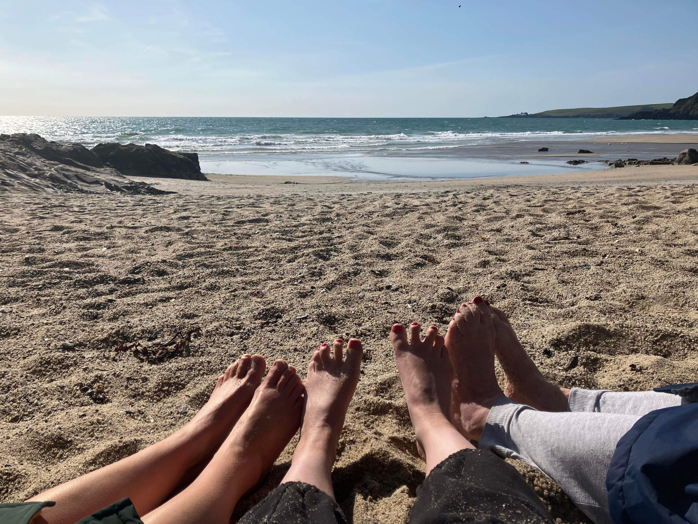 Sitting on the beach with the sun hitting your feet