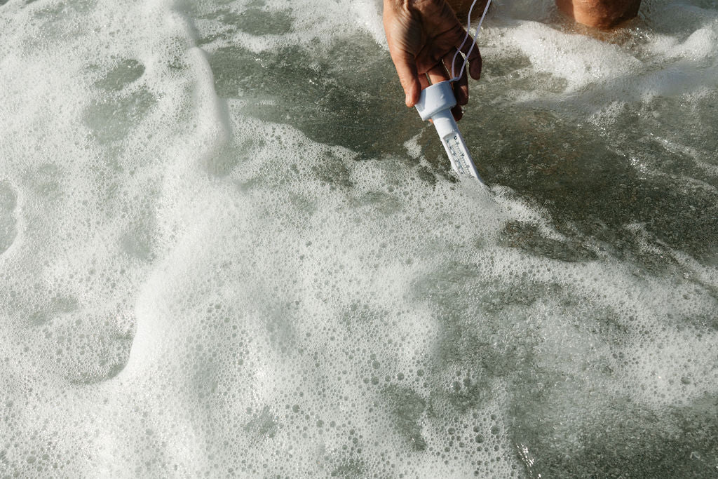 Swimmer checking cold sea water temperature before wild swimming